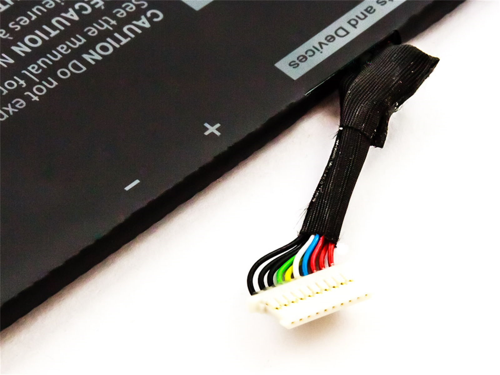 Schwarzer Akku mit Drähten und Stecker. Weißer Hintergrund. Text oben links.