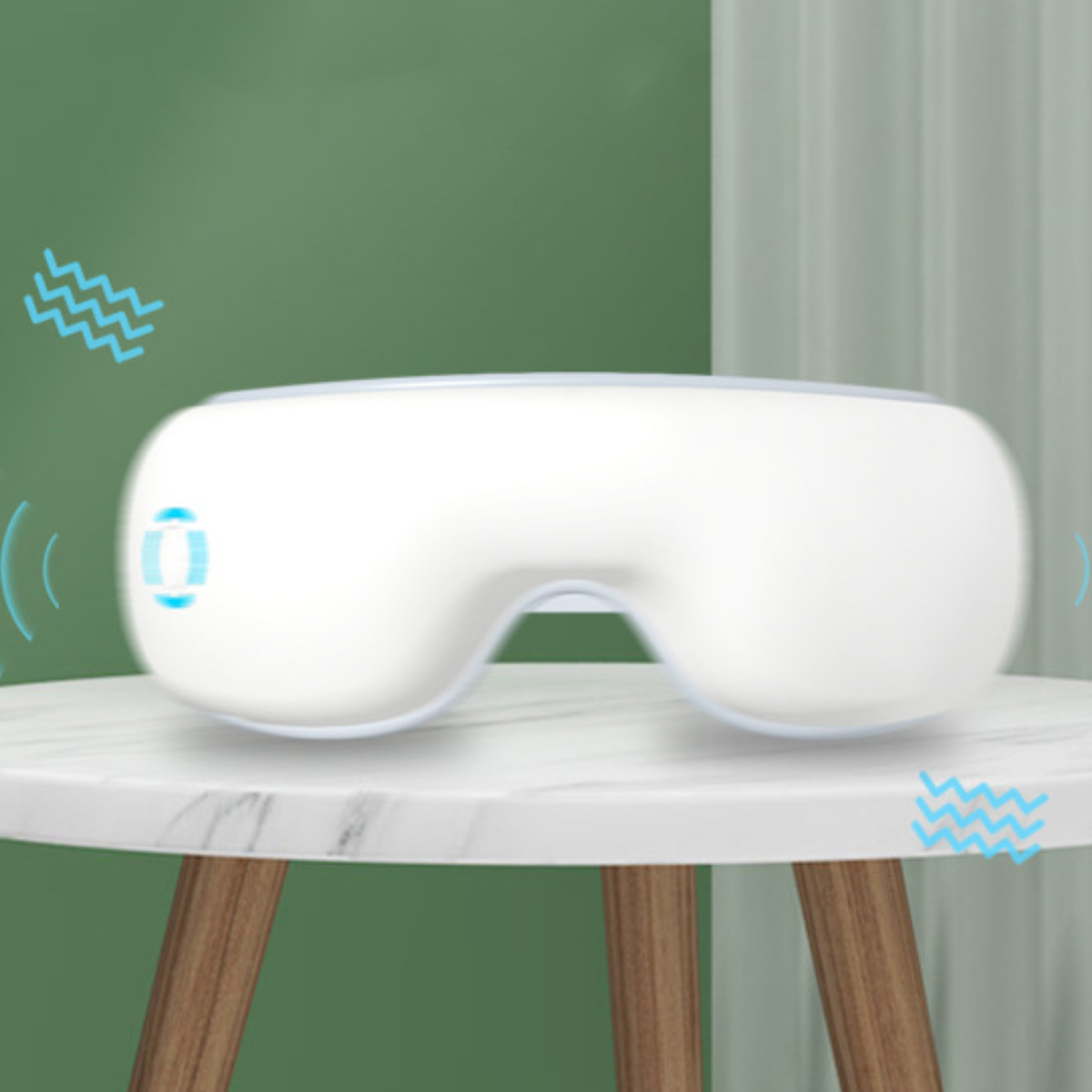 Weißer Augenmassagegerät auf einem Tisch mit grünem Hintergrund, mit blauen Wellensymbolen.