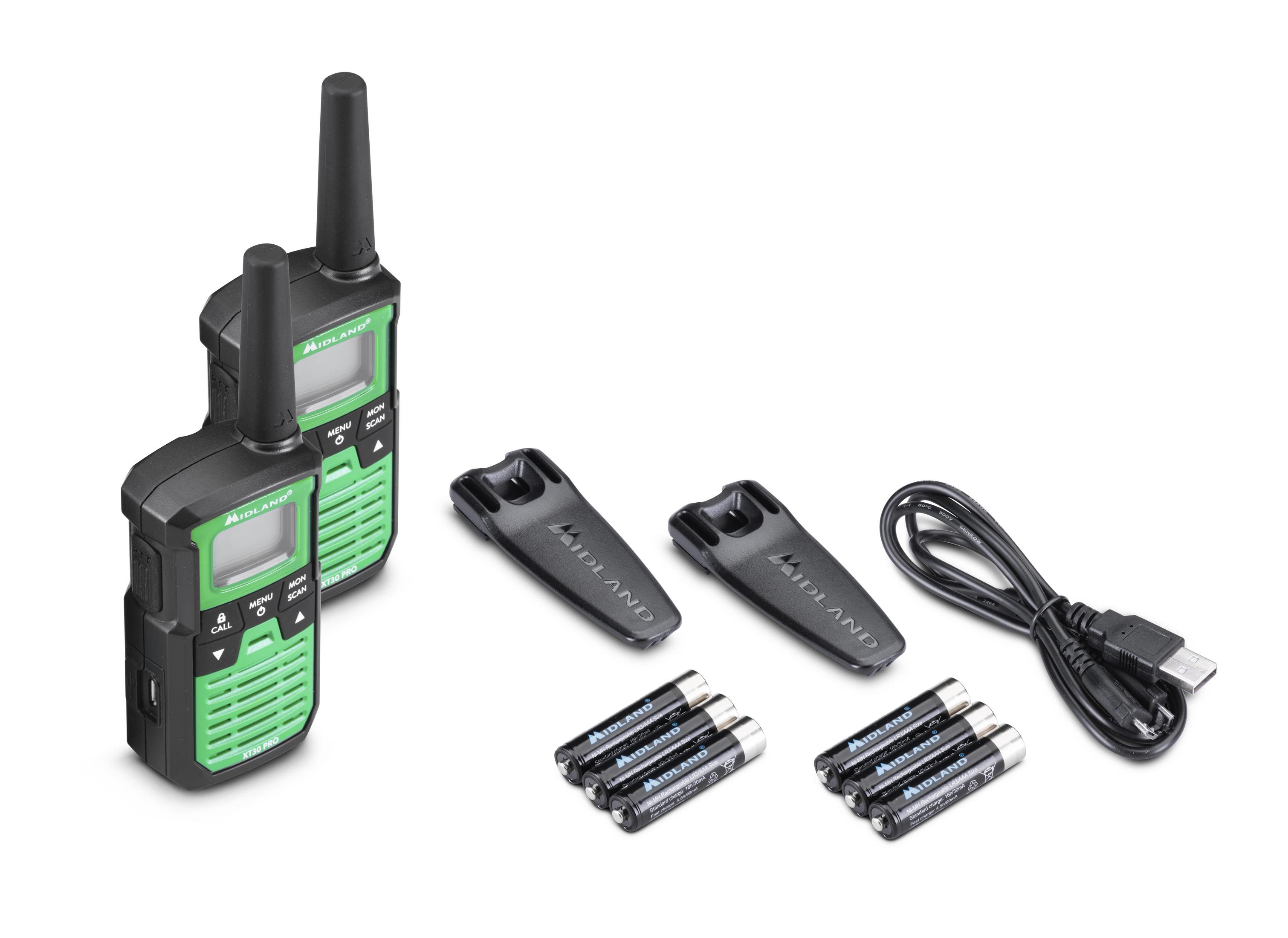 Dwa czarno-zielone krótkofalówki, ładowarka, baterie i klipsy ułożone na białej powierzchni.