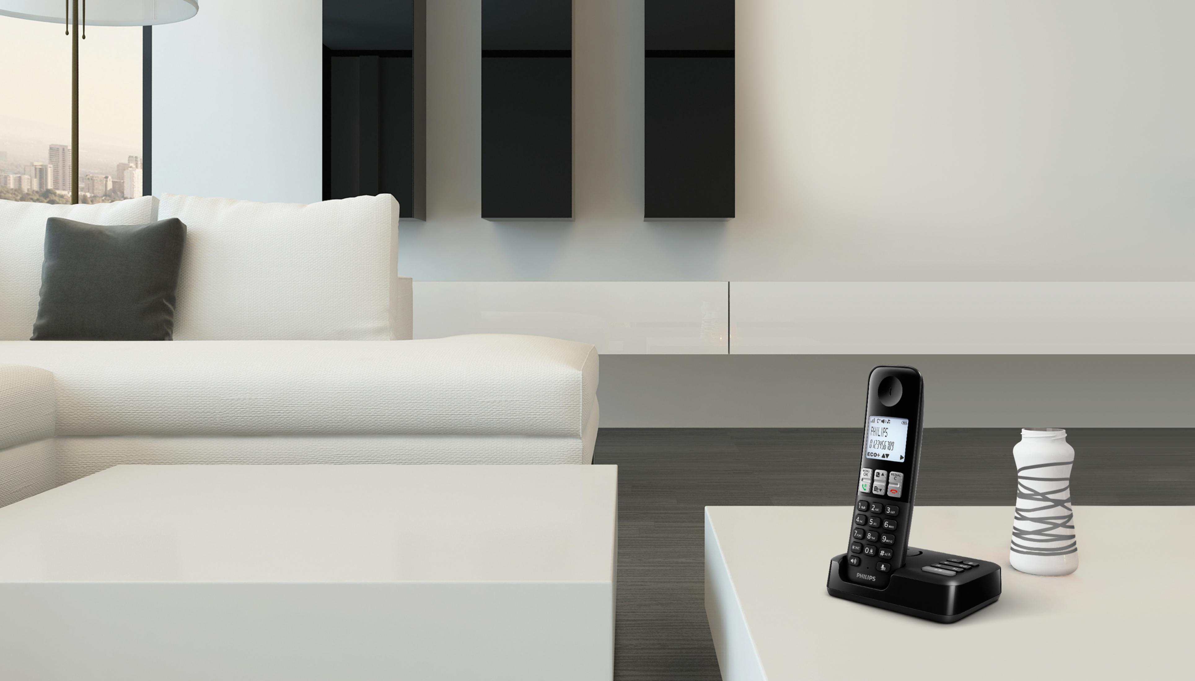 Modernes Wohnzimmer mit weißen Möbeln, einem weißen Tisch und einem schwarzen Telefon.