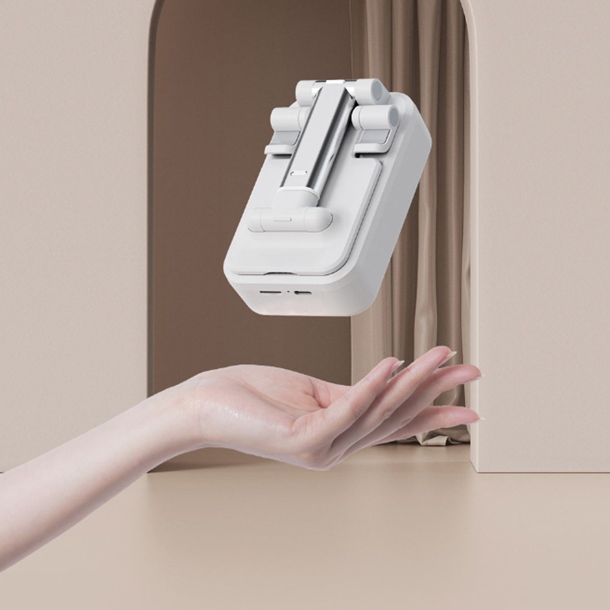 Ein weißer Telefonständer wird von einer Hand vor hellem Hintergrund gehalten.