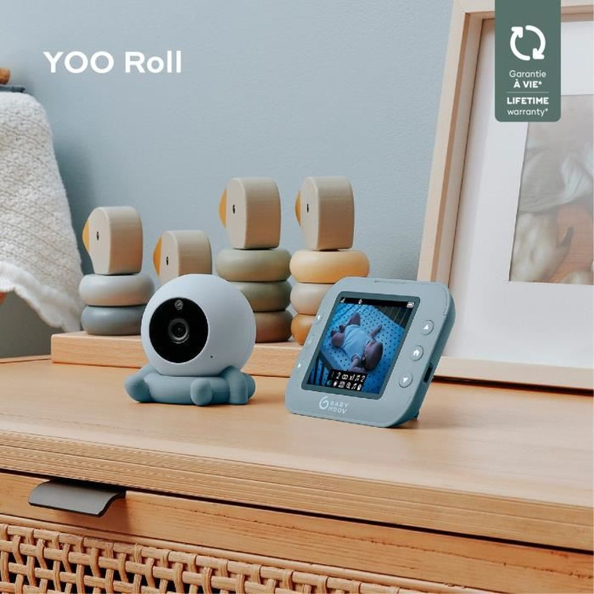 Babyphone mit Kamera und Bildschirm. Holzblöcke sind ebenfalls vorhanden. Text sagt YOO Roll.