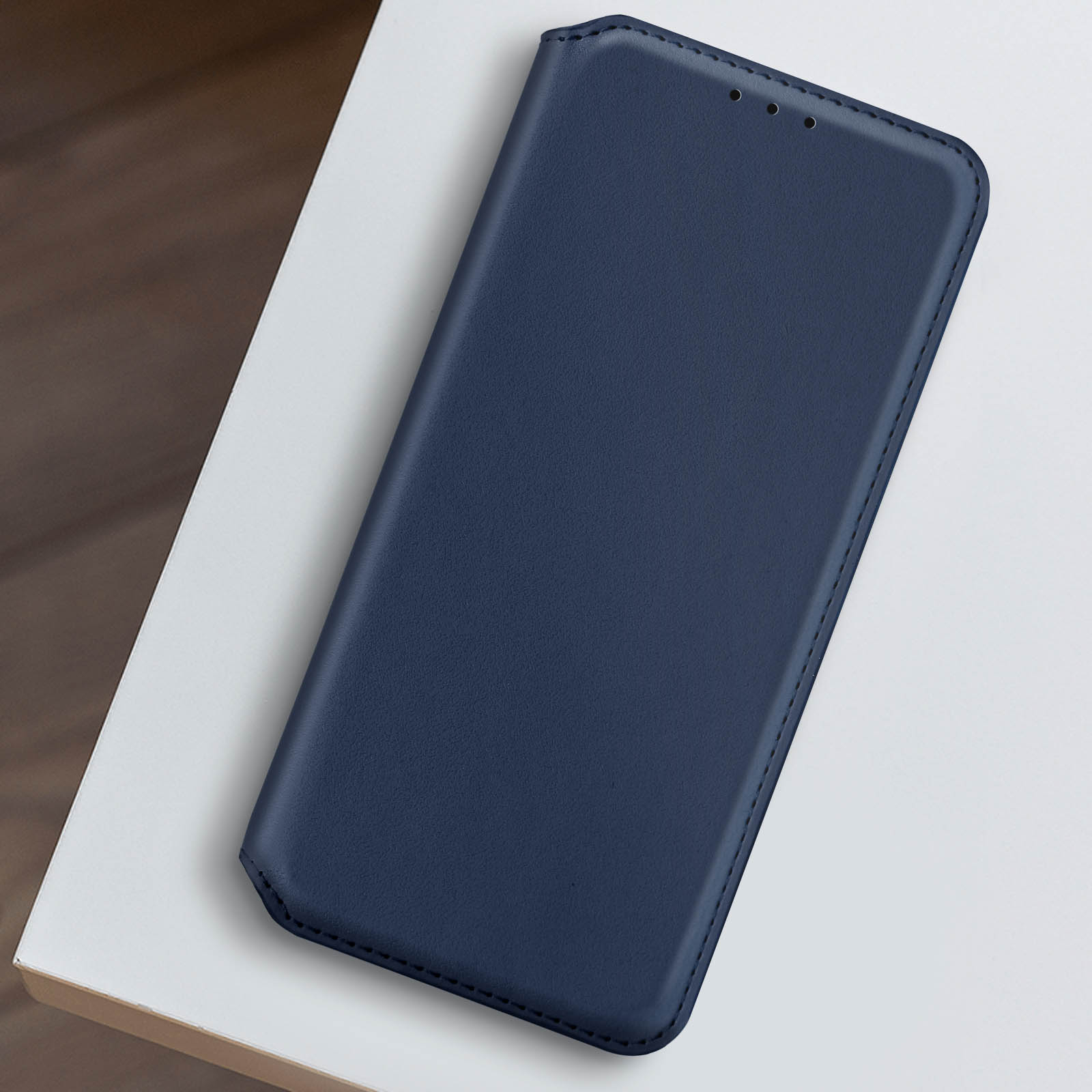 Custodia per telefono blu su una superficie bianca, vista dall'alto, design semplice.