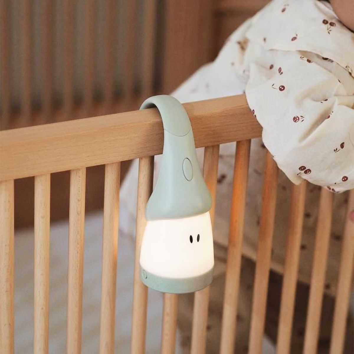 Ein Babybett mit einer niedlichen, leuchtenden Lampe an der Seite. Die Lampe hat die Form eines kleinen Zwergs.