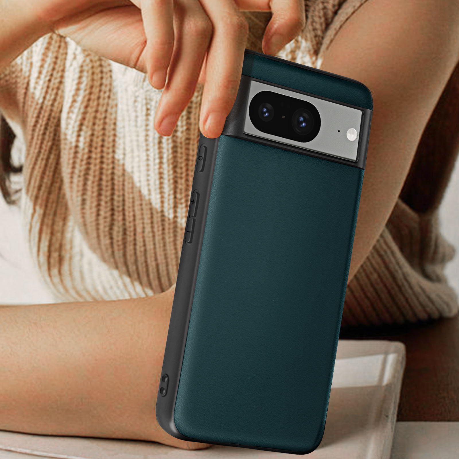 Una mano che tiene una custodia per telefono verde acqua con una sezione fotocamera nera.