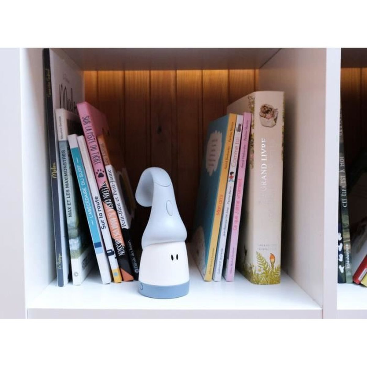 Bücherregal mit Büchern und einem weißen Nachtlicht in der Mitte.