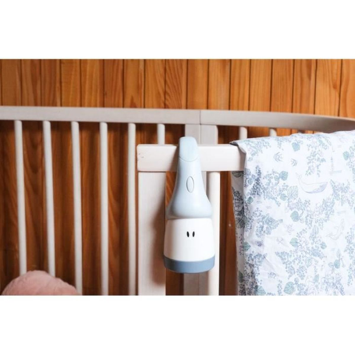 Weiß-blauer Babyschnuller am Kinderbett, mit Decke.