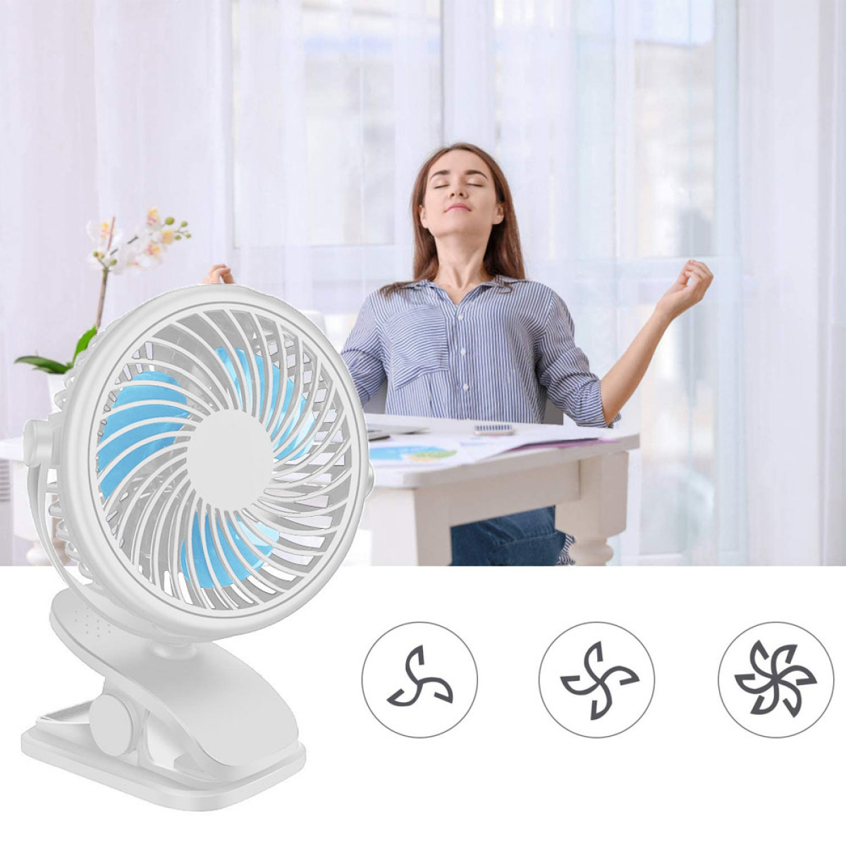 Ein weißer Clip-On-Ventilator mit blauen Flügeln, eine Frau sitzt hinter einem Schreibtisch mit einer Blume.