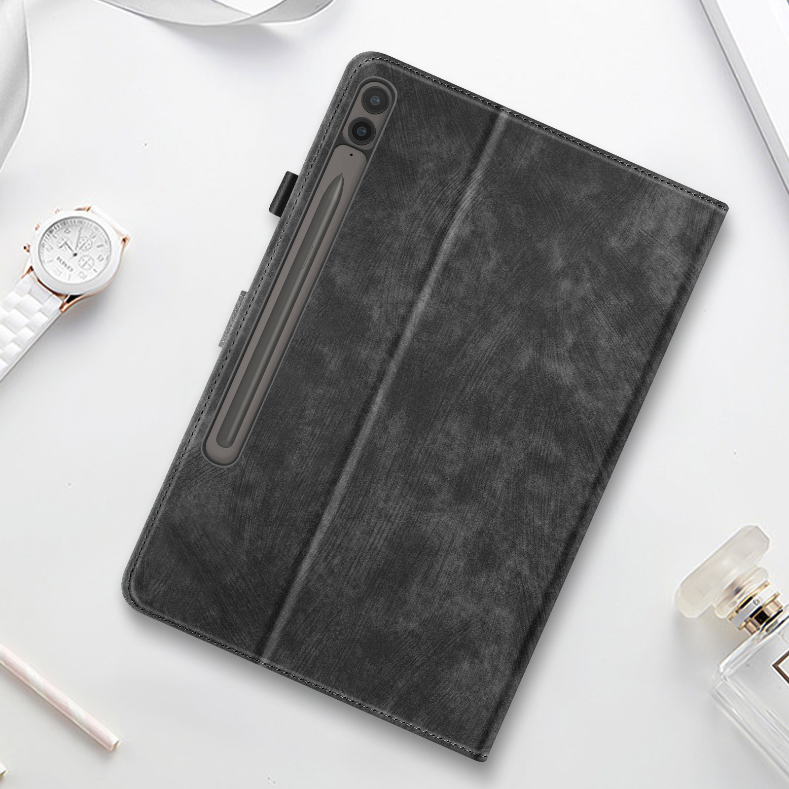 Una custodia per tablet con stilo e accessori su una superficie bianca.