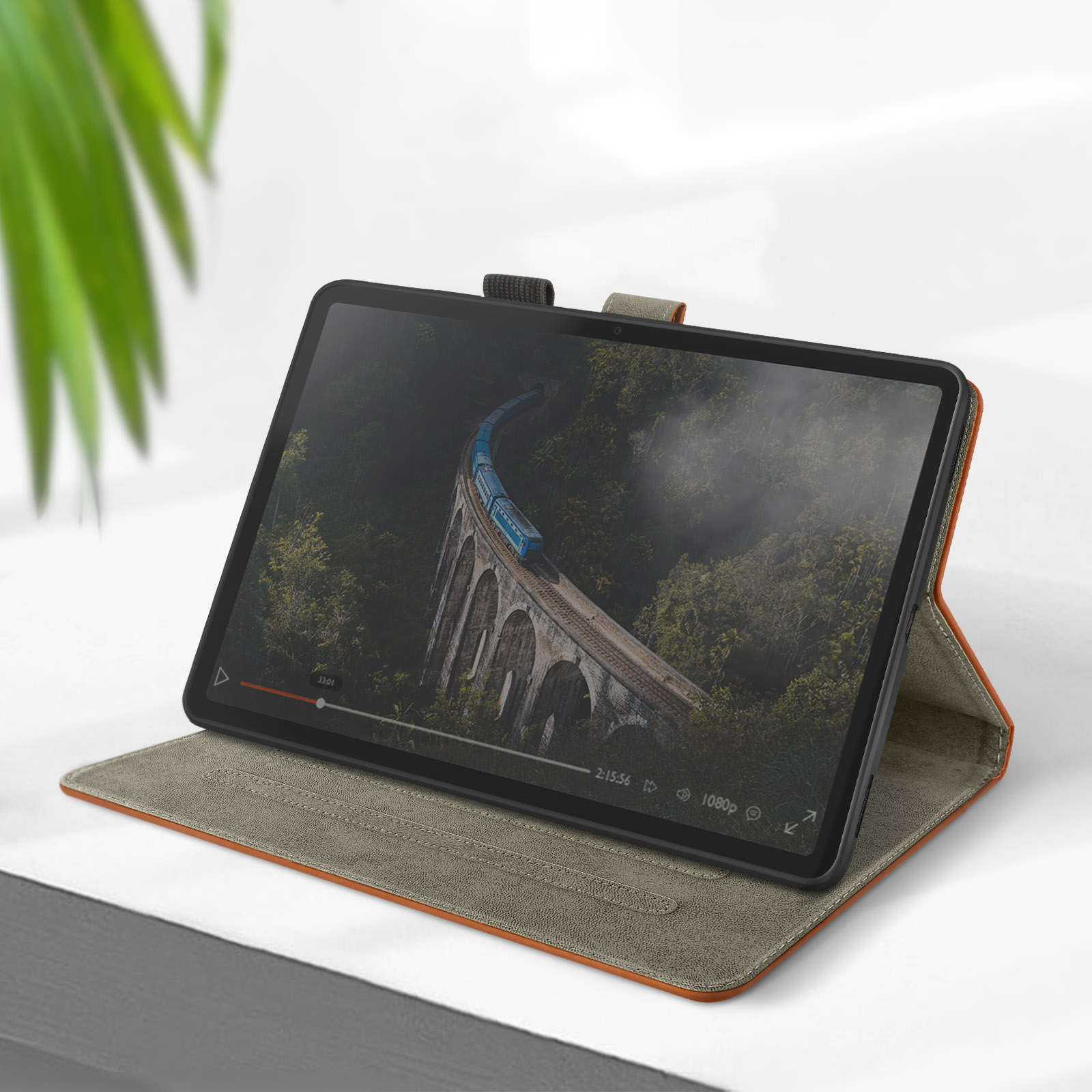 Tablet che riproduce un video di un ponte, in una custodia protettiva, su una superficie bianca.