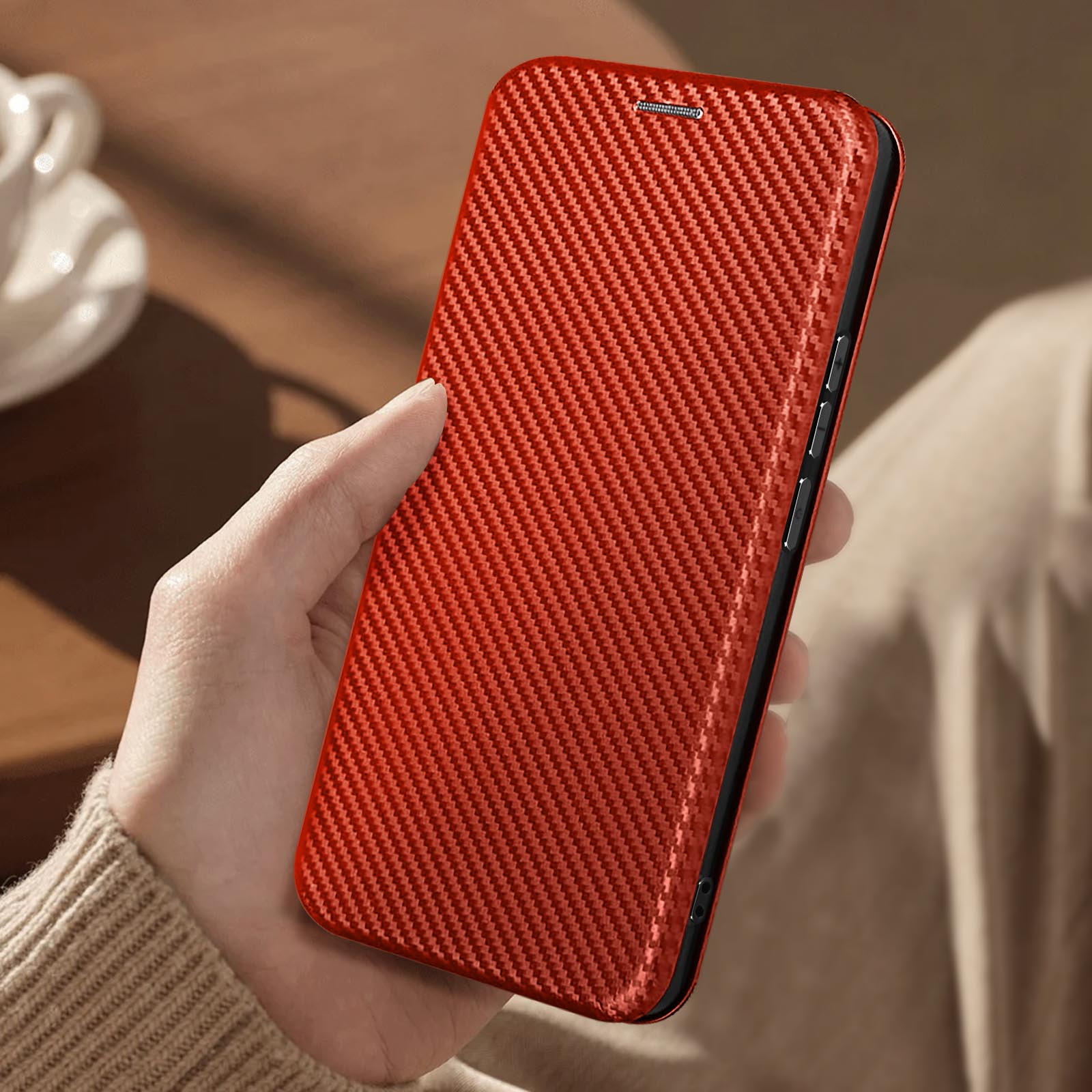 Una mano tiene una custodia per telefono rossa strutturata. La custodia ha un motivo simile alla fibra di carbonio.
