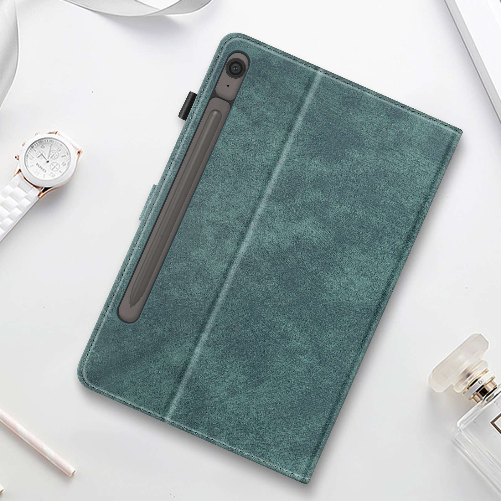 Una custodia per tablet verde acqua con uno stilo. La custodia è su una superficie bianca con altri accessori.