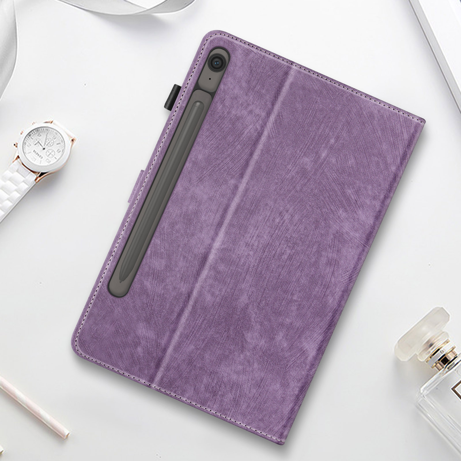Custodia per tablet viola con stilo. Sfondo bianco con orologio e profumo.