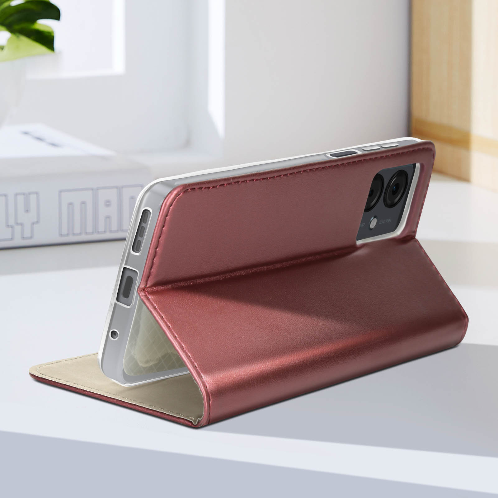 Geöffnete rote Handyhülle mit Telefon, auf einer Oberfläche, mit Fenster im Hintergrund.