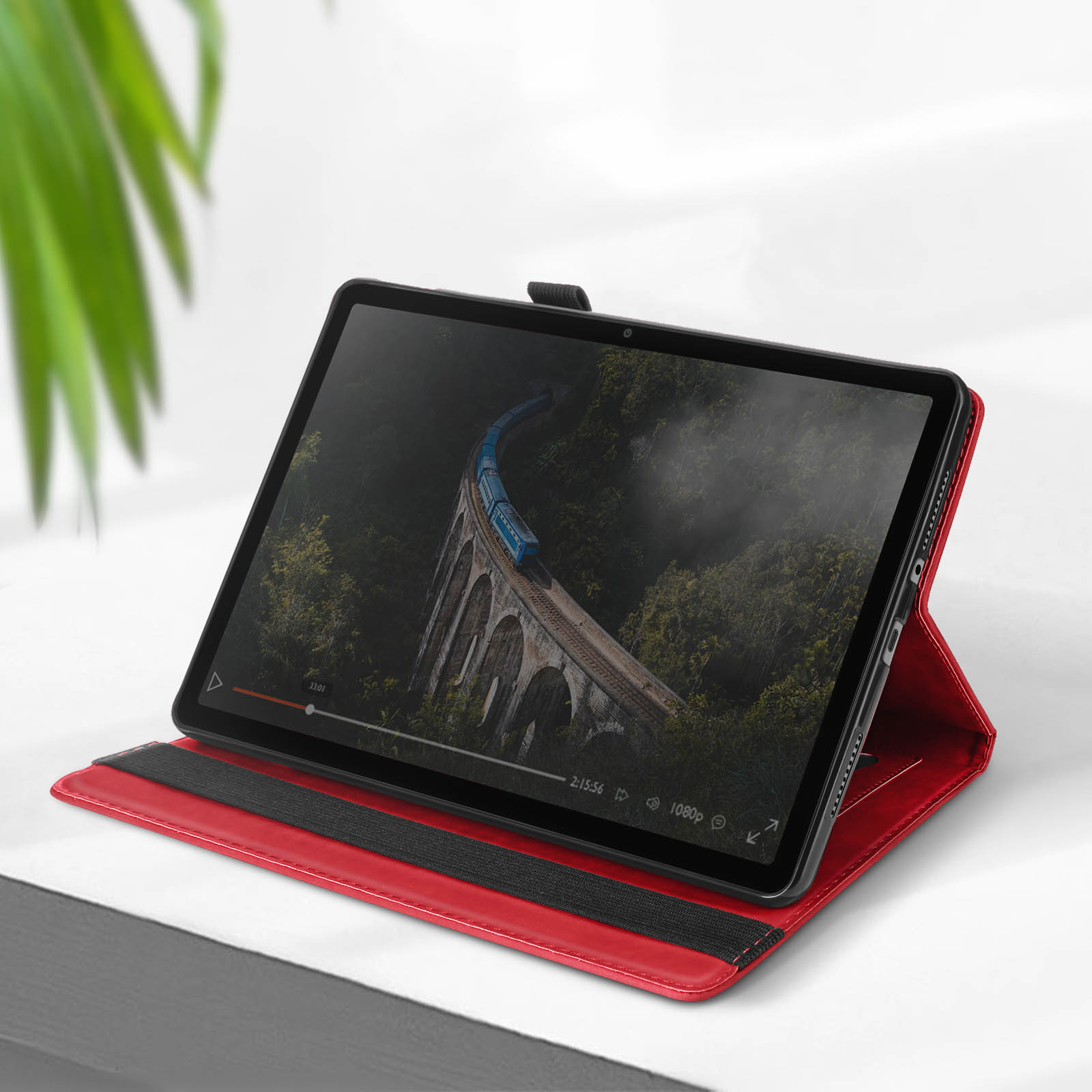 Un tablet in una custodia rossa che mostra un video di un treno su un ponte.