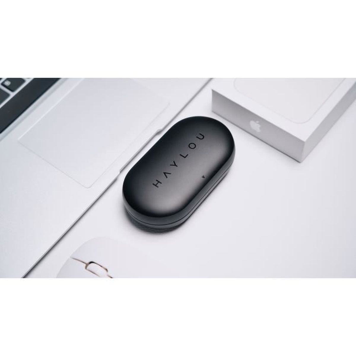Schwarzes Ohrhörer-Etui mit der Aufschrift 'HAYLOU', in der Nähe eines Laptops und einer weißen Box.