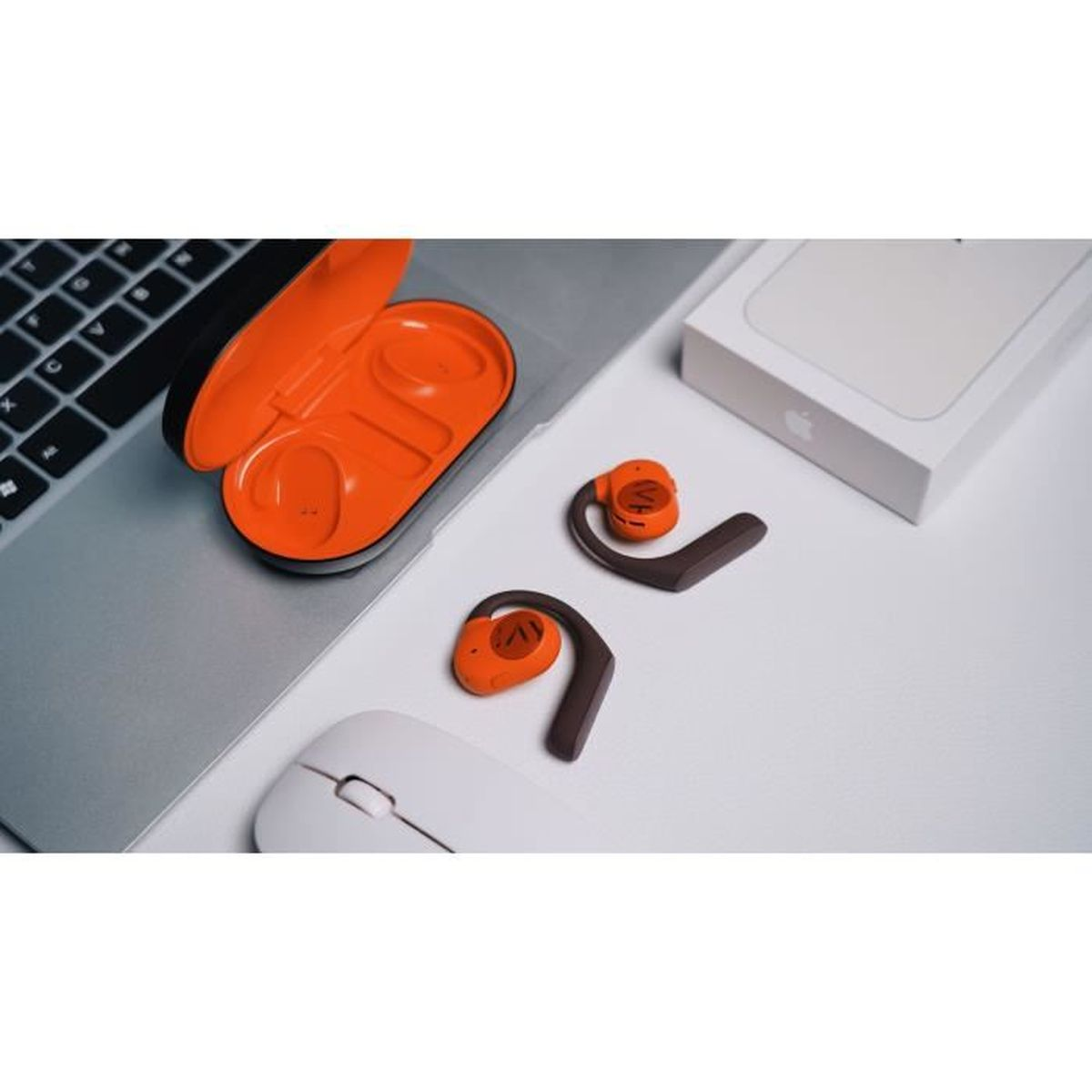 Kabellose Kopfhörer, Etui und anderes Zubehör auf einem Laptop. Orange und braun.