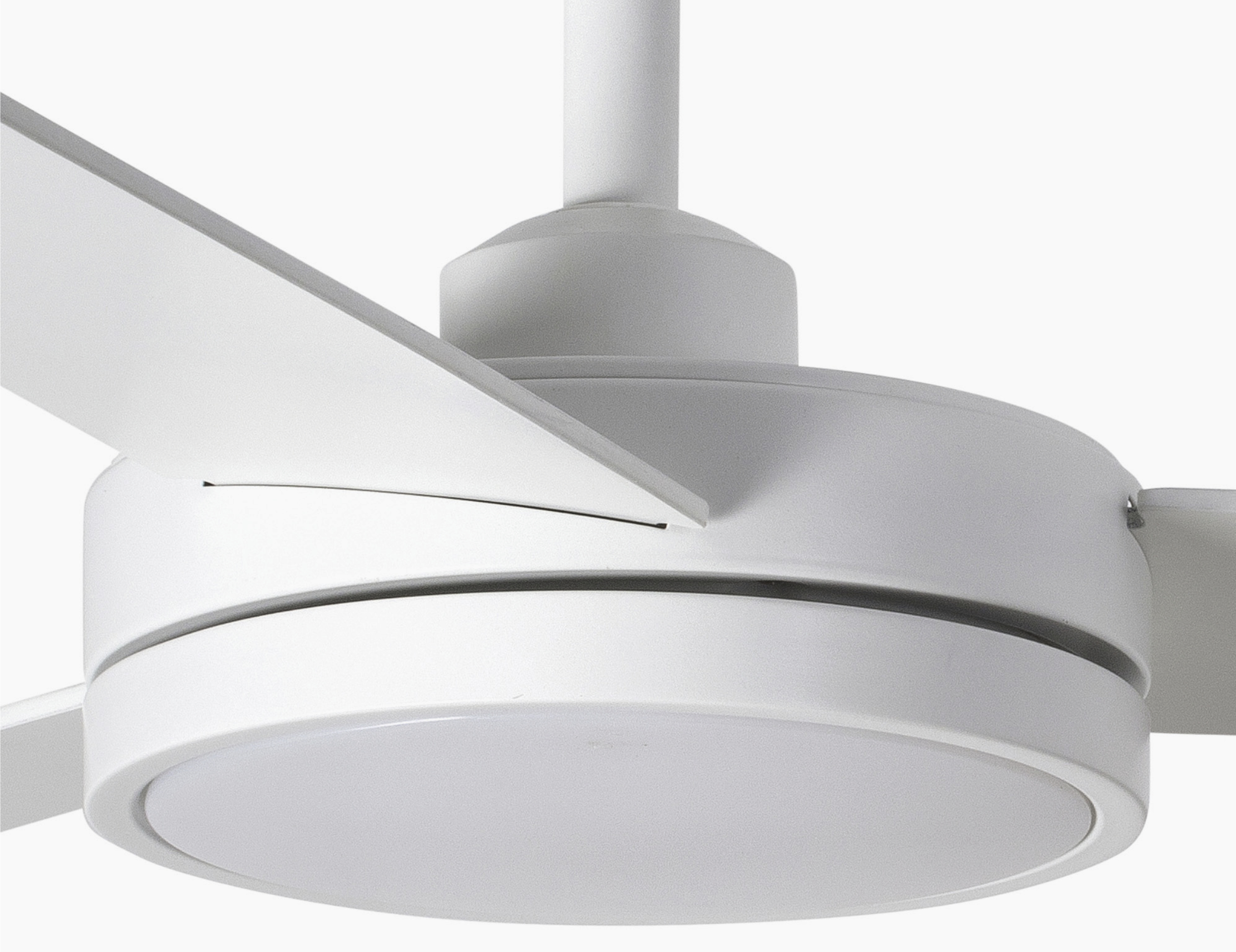 Primo piano di un ventilatore da soffitto bianco. Sono visibili pale bianche e un apparecchio di illuminazione bianco.