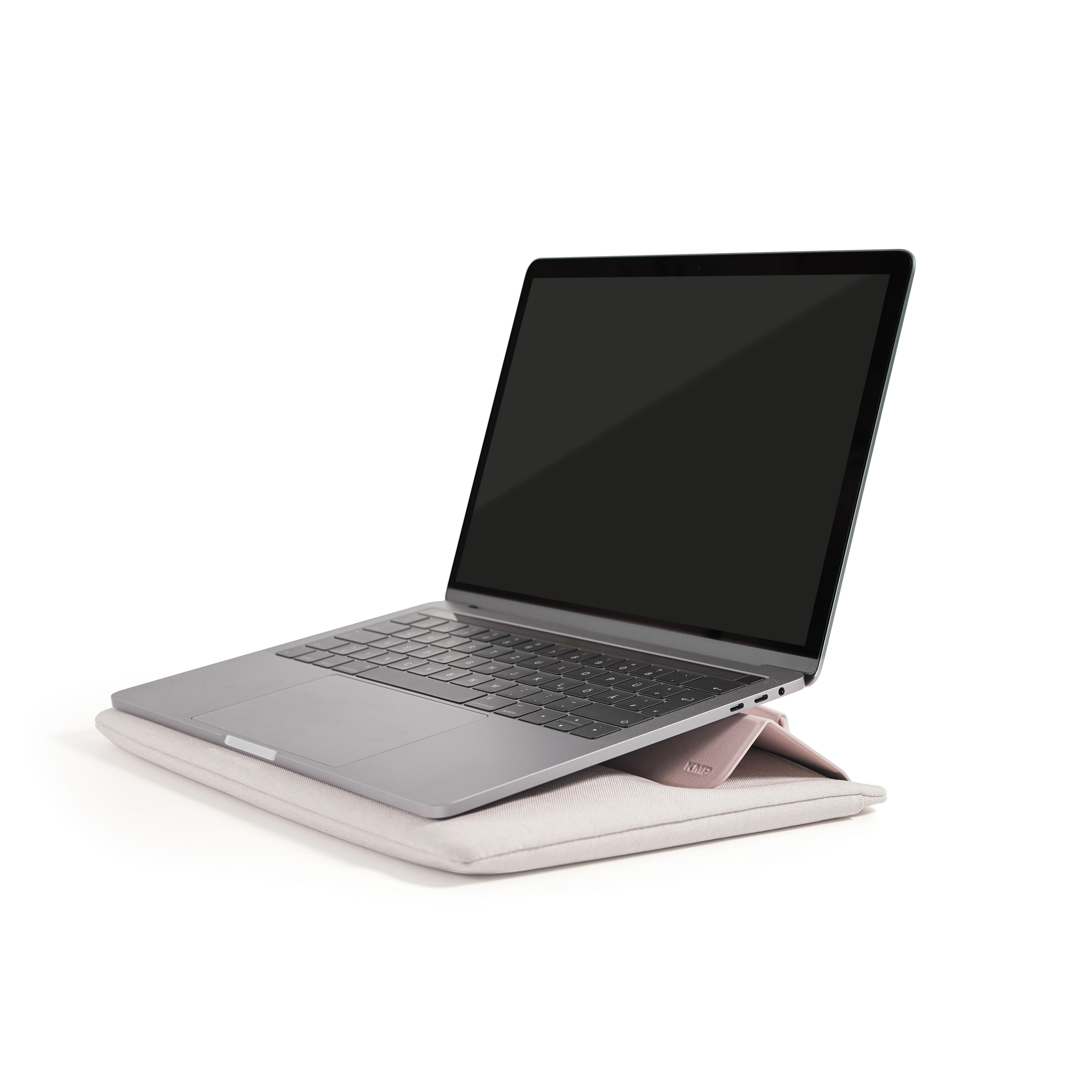 Ein silberner Laptop auf einem rosafarbenen Kissen, mit einem schwarzen Bildschirm.