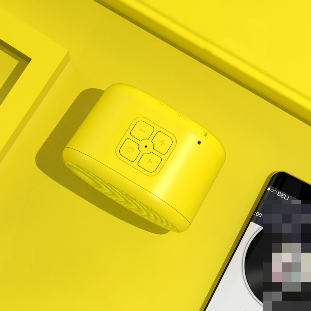 Ein gelber Lautsprecher mit Knöpfen und einem Telefon. Das Telefon ist weiß mit schwarzem Bildschirm auf gelber Fläche.