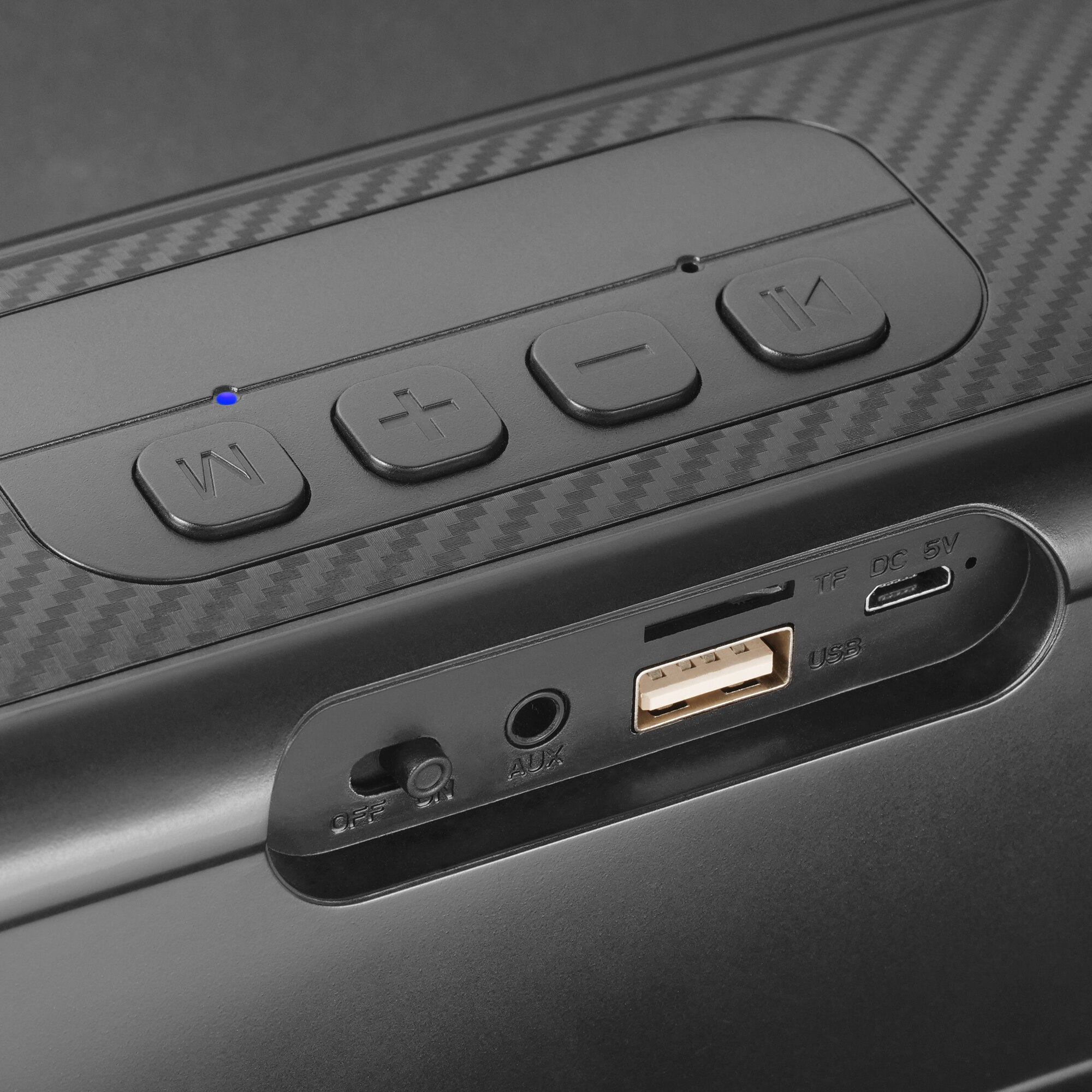 Zbliżenie czarnego głośnika z przyciskami i portami, w tym USB, TF, AUX i przełącznikiem włączania/wyłączania.