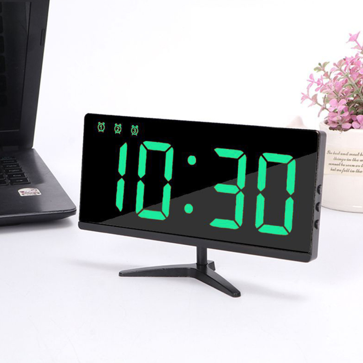 Digitaluhr mit grünen Ziffern 10:30 und schwarzem Rahmen.