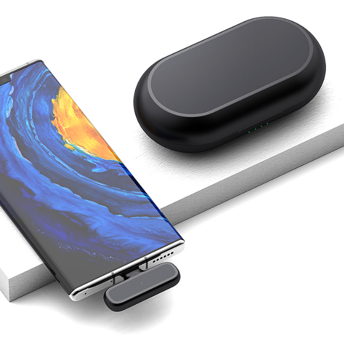 Smartphone und schwarzes kabelloses Ladegerät. Das Ladegerät ist oval und hat ein kleines grünes Licht.