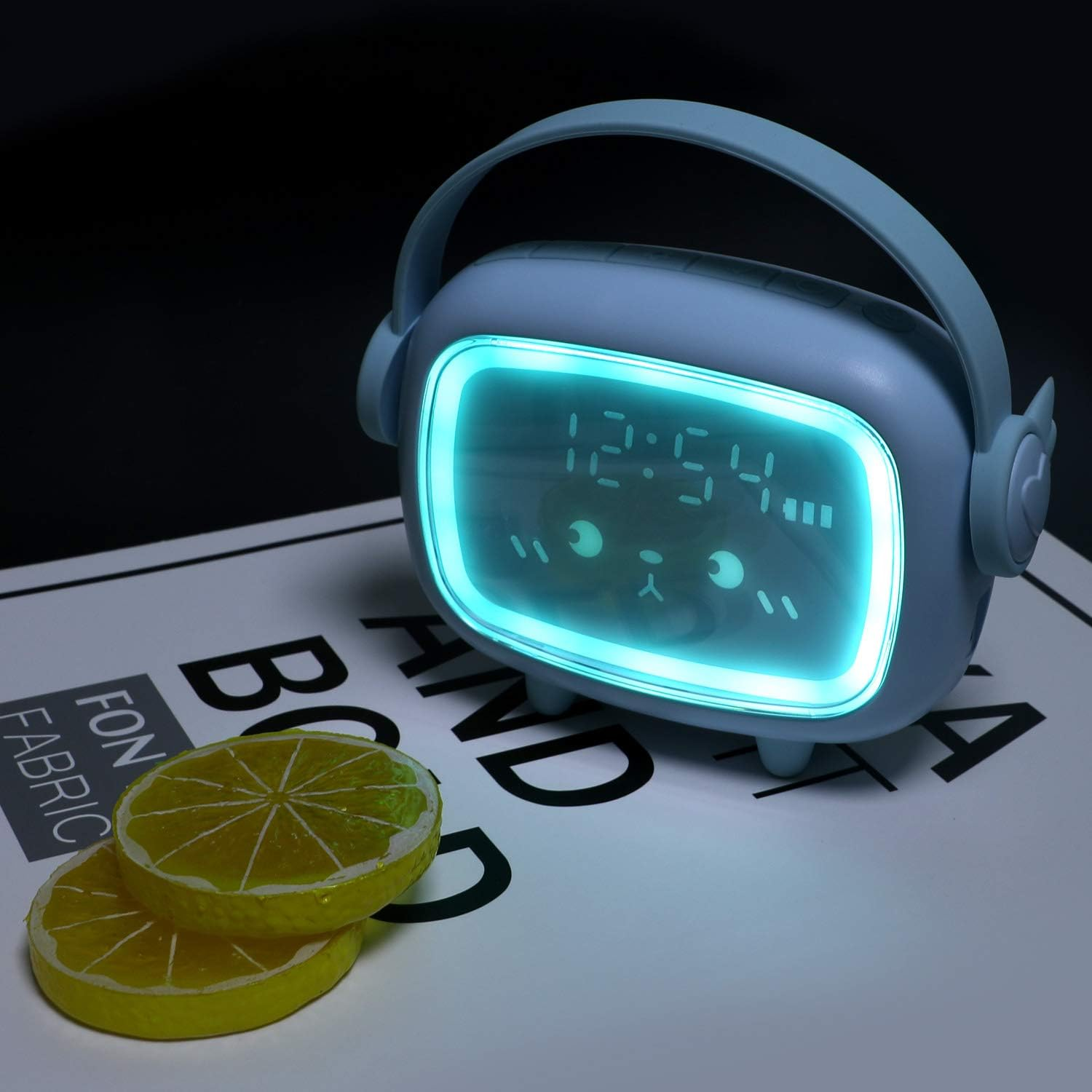 Blauer Radiowecker mit Griff und bärenförmigem Gesicht mit leuchtendem Display.