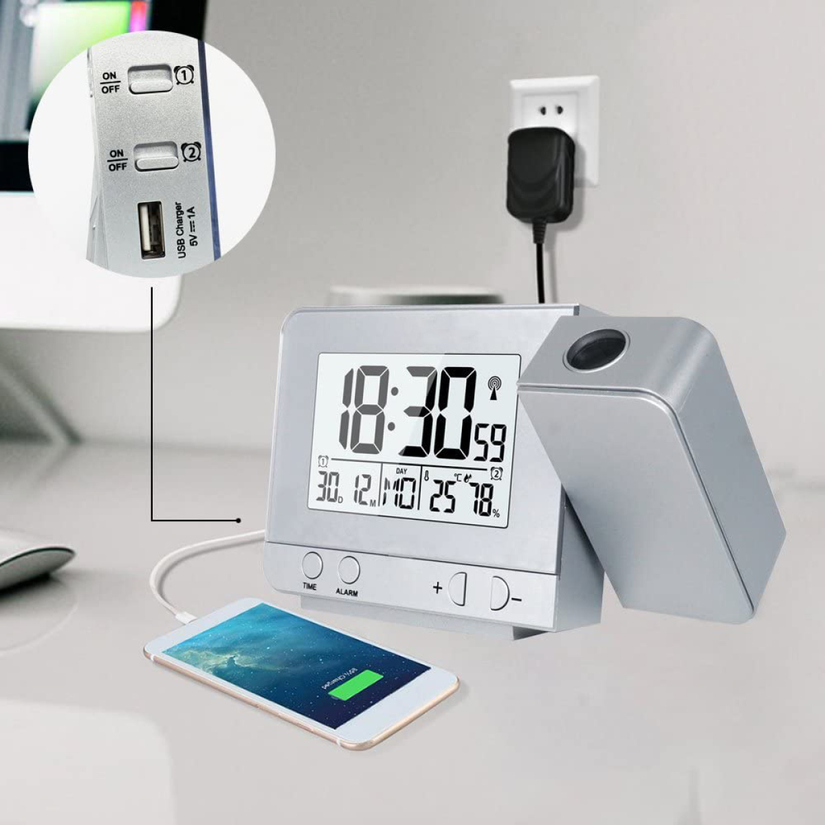 Eine Digitaluhr mit 10:30. Ein Smartphone und Ladegerät daneben. Weiße Oberfläche.