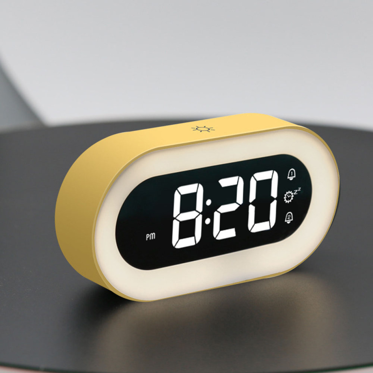 Gelber Wecker mit der Anzeige 20:20 Uhr. Die Uhr steht auf einer schwarzen Oberfläche.