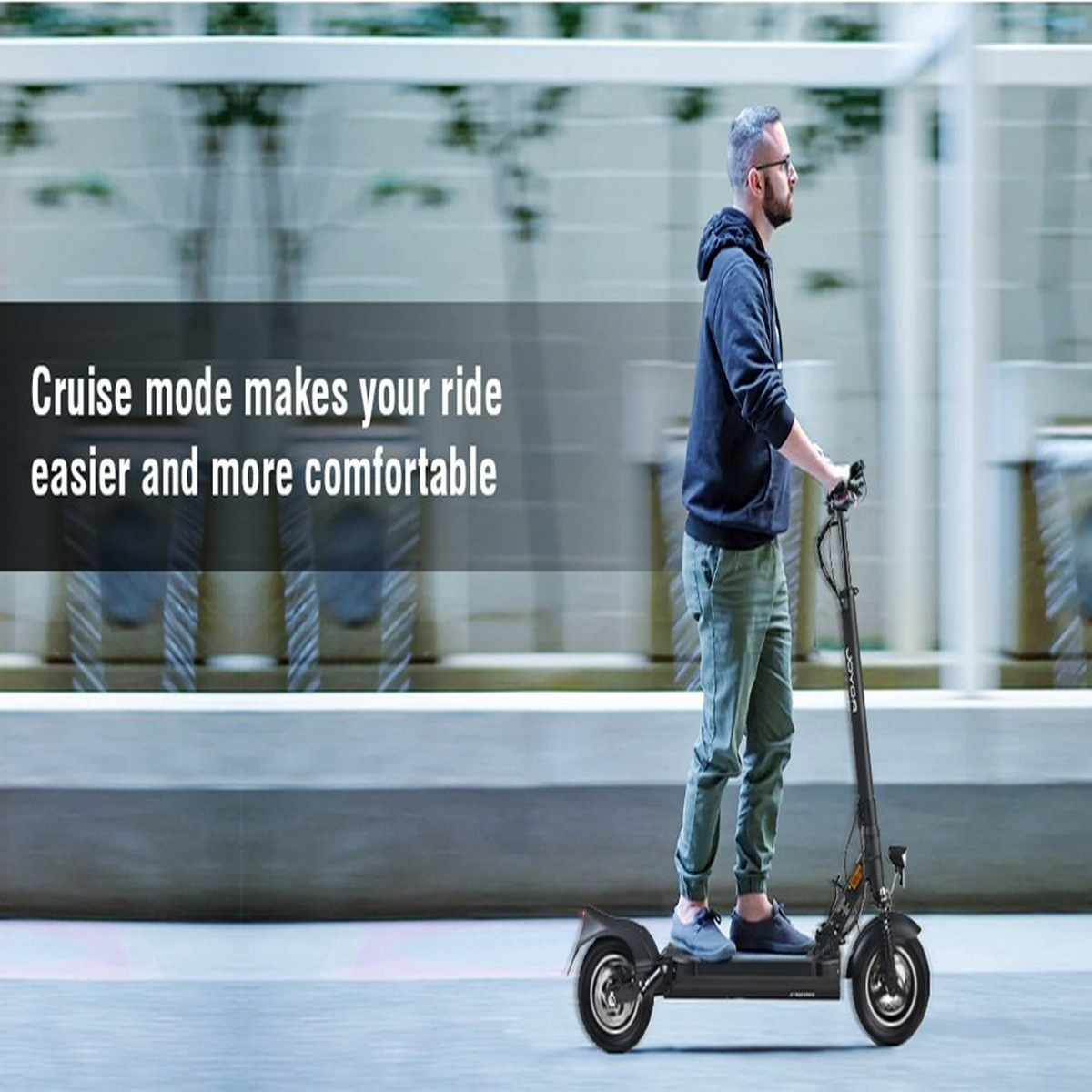 Ein Mann fährt auf einer asphaltierten Straße einen schwarzen Roller. Text: 'Cruise-Modus macht Ihre Fahrt einfacher und komfortabler'.