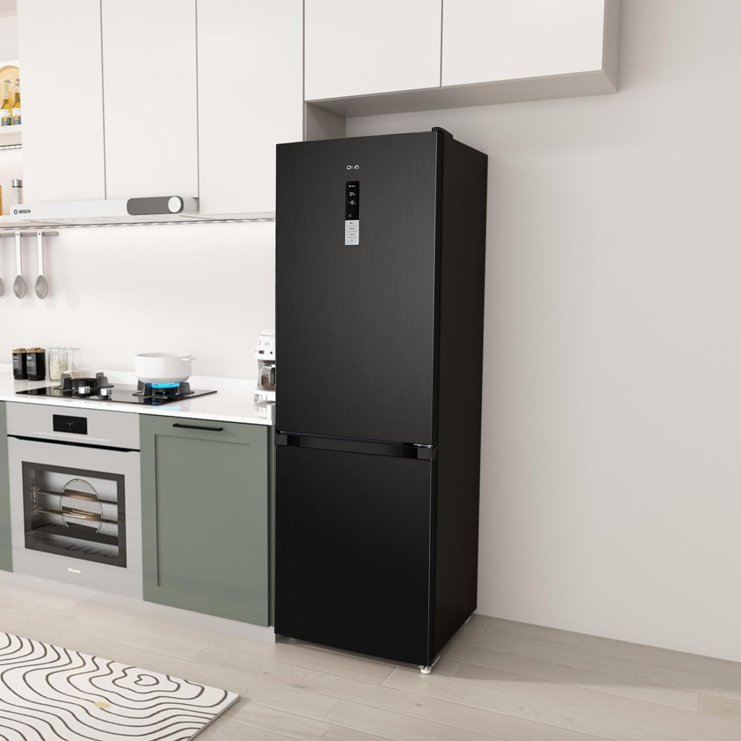 A black refrigerator stands in a kitchen. The kitchen has white cabinets and a stove.