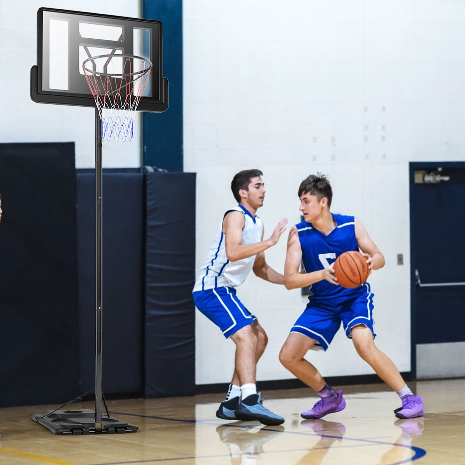 Zwei Männer spielen Basketball. Einer dribbelt, der andere verteidigt. Basketballkorb im Hintergrund.