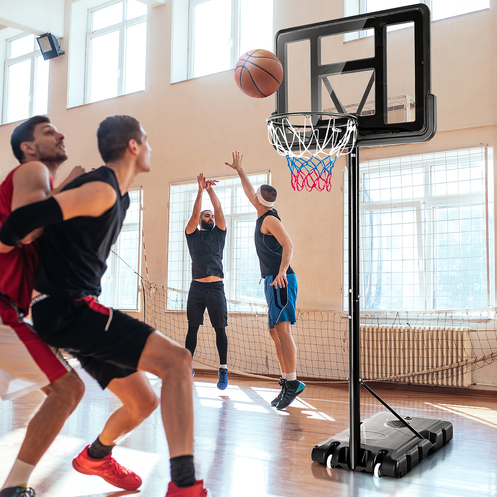 Basketballspiel in einer Turnhalle. Spieler schießen und verteidigen den Ball.