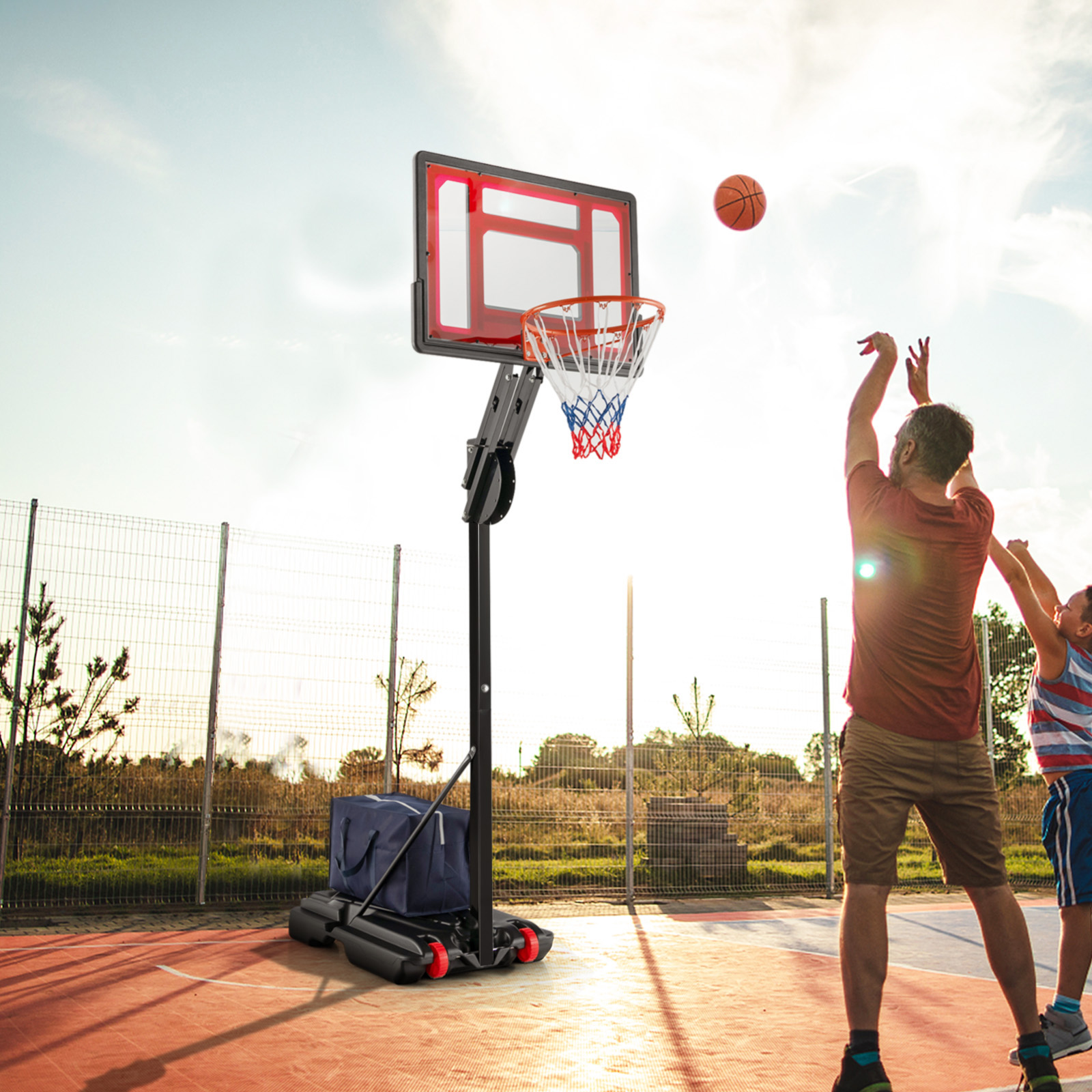 Zwei Personen spielen Basketball, eine wirft, Outdoor-Platz.