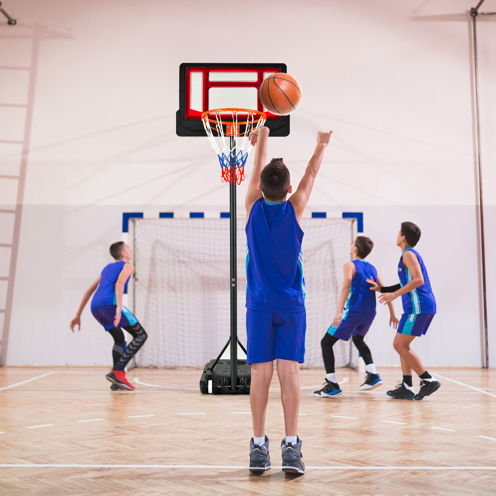 Jungen spielen Basketball, einer wirft, Korb im Hintergrund.