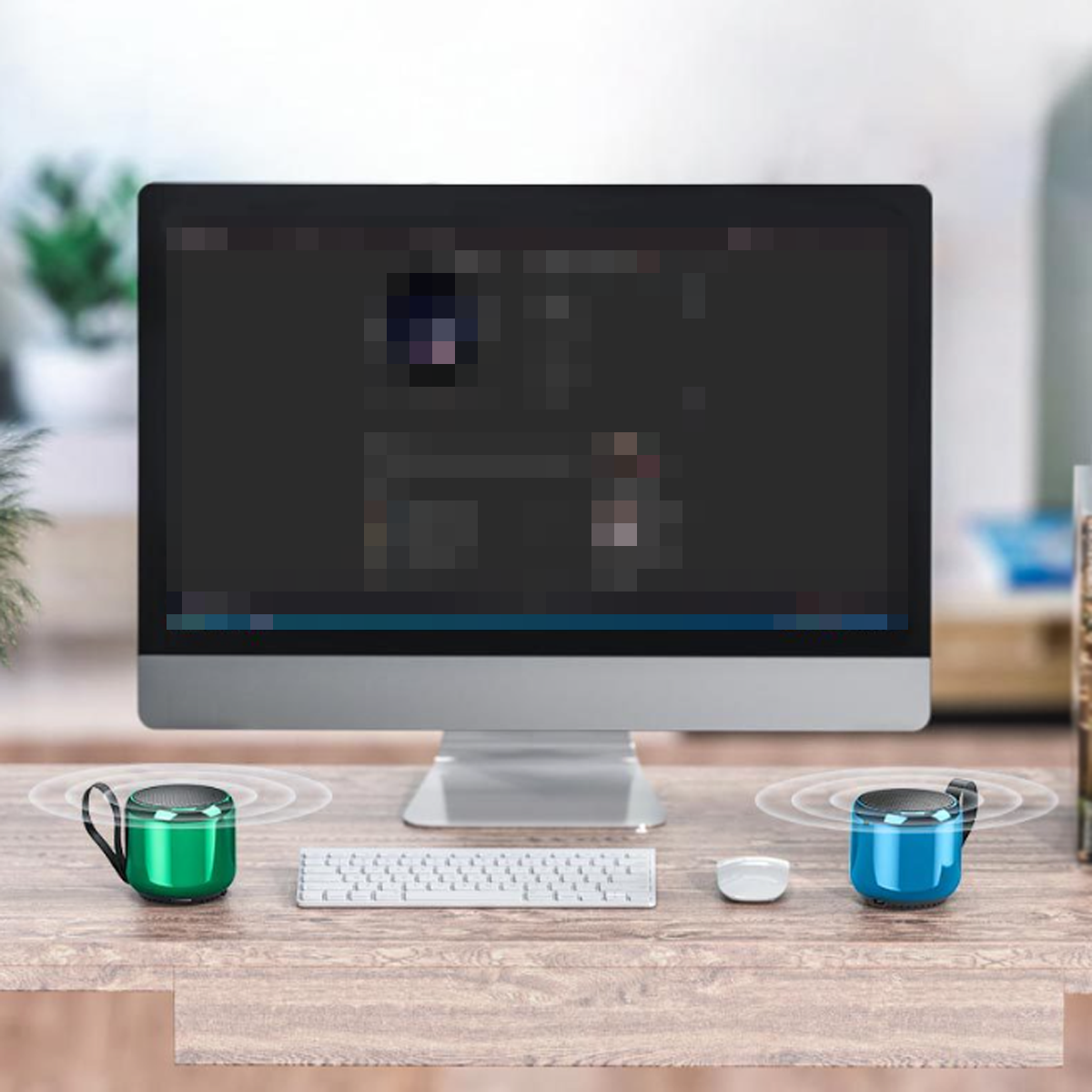 Zwei kleine grüne und blaue Lautsprecher auf einem Holztisch, Computermonitor, Tastatur und Maus im Hintergrund.