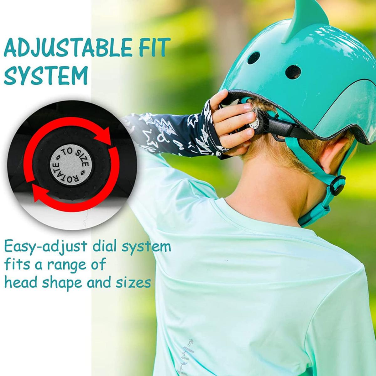 Ein Kind mit einem türkisblauen Helm. Der Helm hat eine Haifischflosse und den Text "ADJUSTABLE FIT SYSTEM".