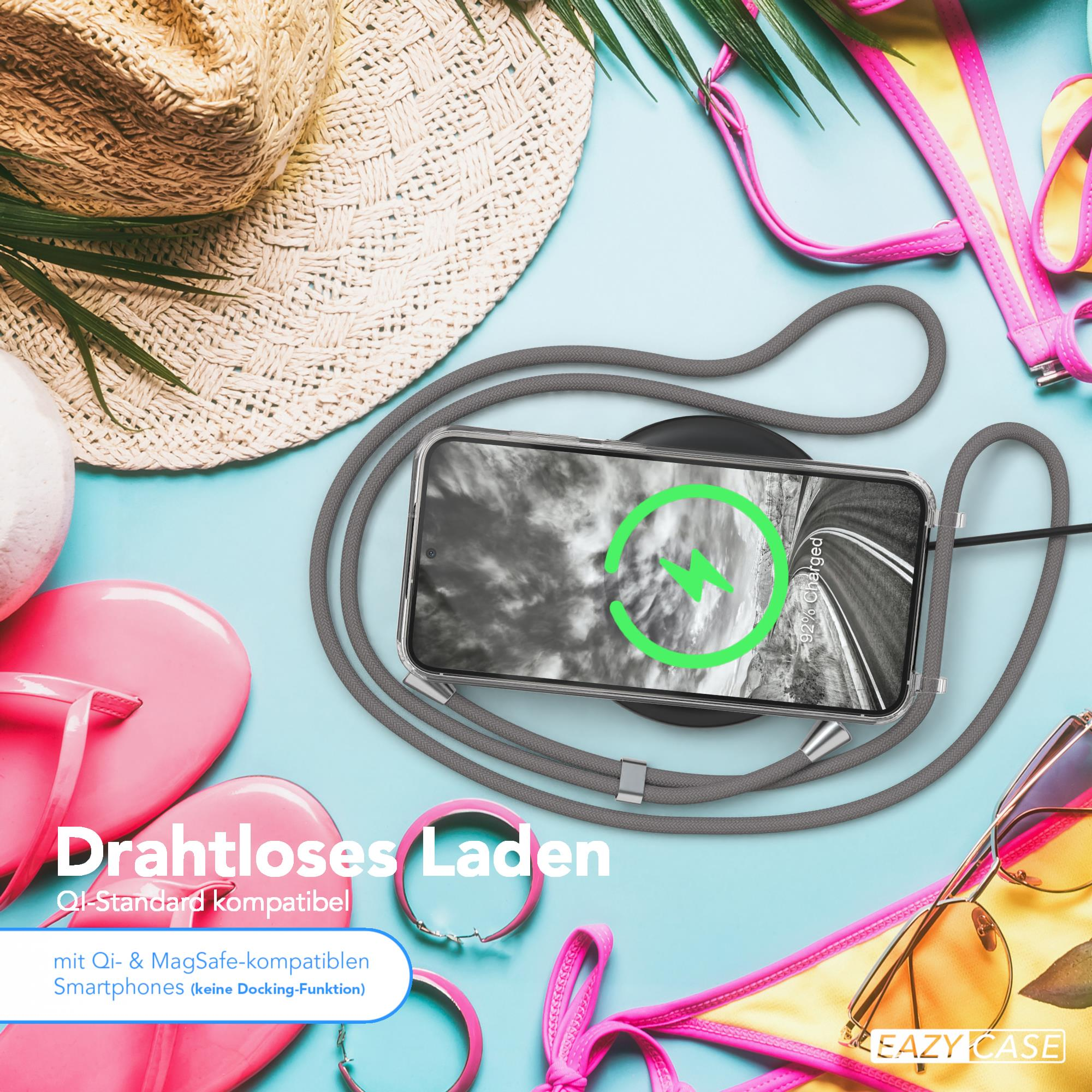 Telefon auf kabellosem Ladegerät mit grauem Kabel. Sonnenbrille und Strandaccessoires auf blauem Hintergrund.