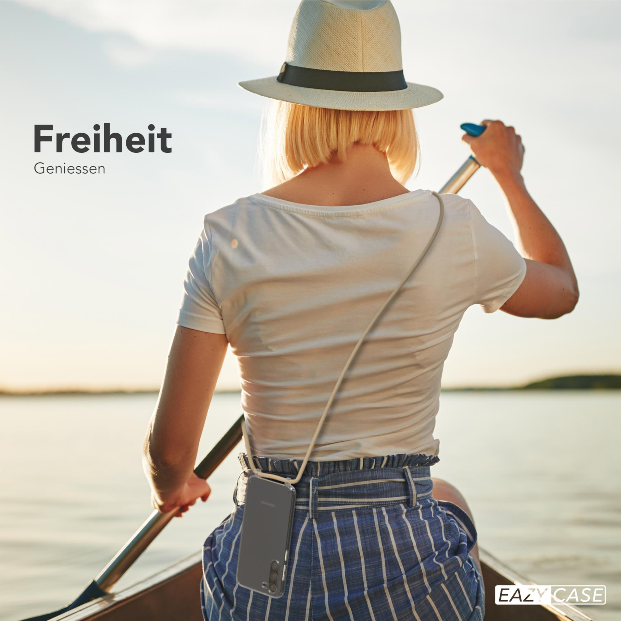 Frau in einem Boot, das auf einem See paddelt, Telefon an einem Schlüsselband. Text: Freiheit genießen.