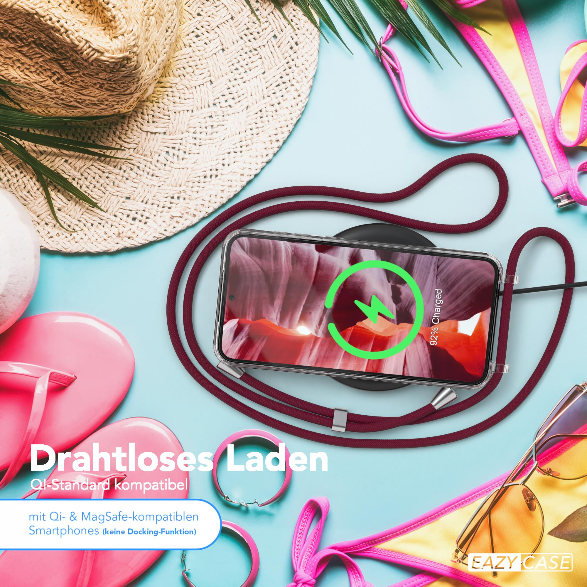 Telefon auf Ladegerät mit Sommer-Strandaccessoires: Hut, Sonnenbrille und Bikini-Oberteil.