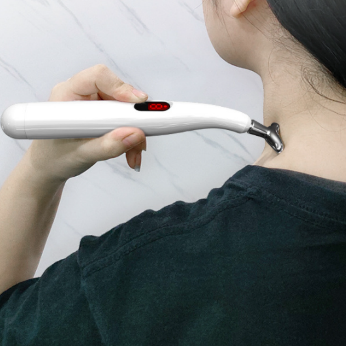 Eine Frau benutzt ein weißes Massagegerät an ihrem Hals. Das Gerät hat eine rote Digitalanzeige.