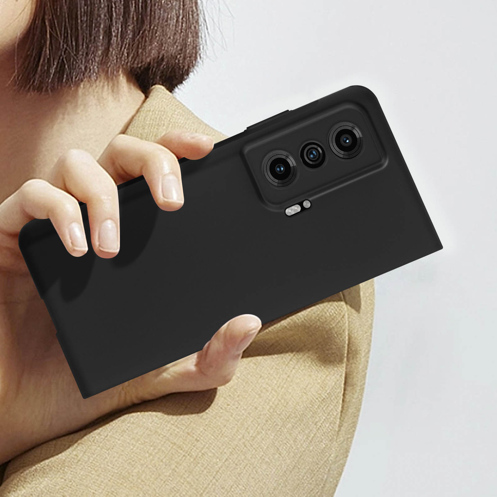 Una custodia per telefono nera con un ritaglio per la fotocamera, tenuta in mano.