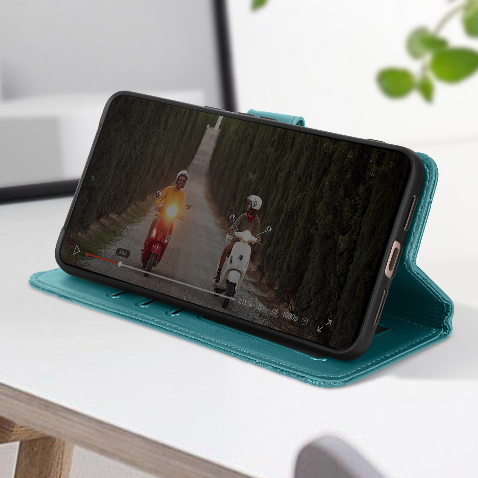 Ein Smartphone in einer tealfarbenen Hülle zeigt ein Video von zwei Rollern auf einer Straße.