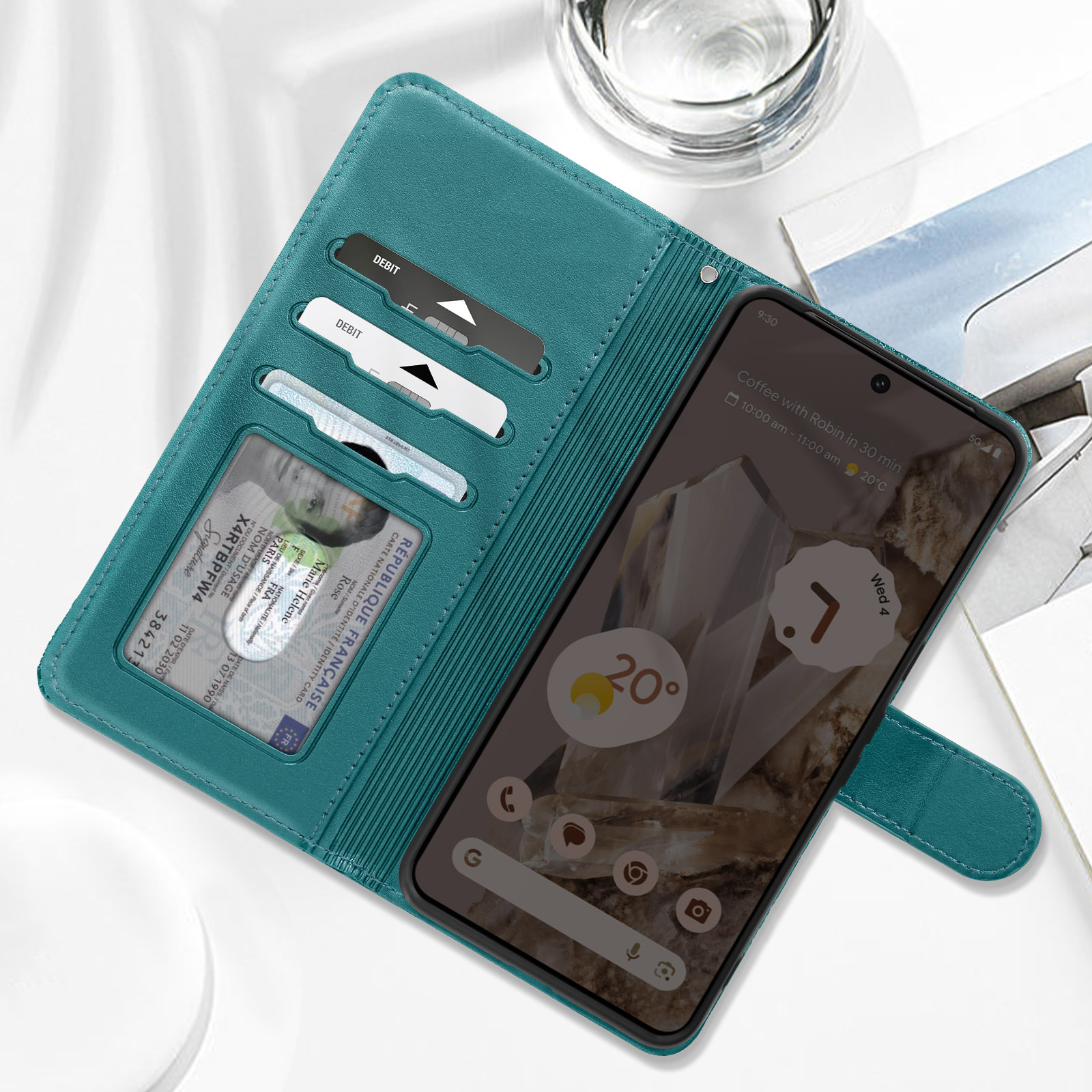 Türkisfarbene Handyhülle offen, hält Telefon, Ausweis, Karten. Telefon zeigt App.