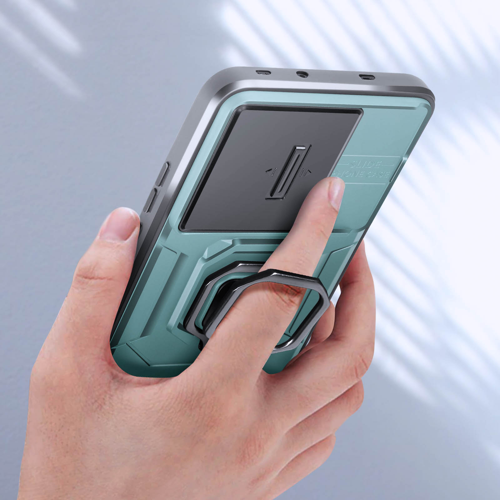 Una mano che tiene una custodia per telefono color verde acqua con un'impugnatura ad anello. Il telefono è angolato.