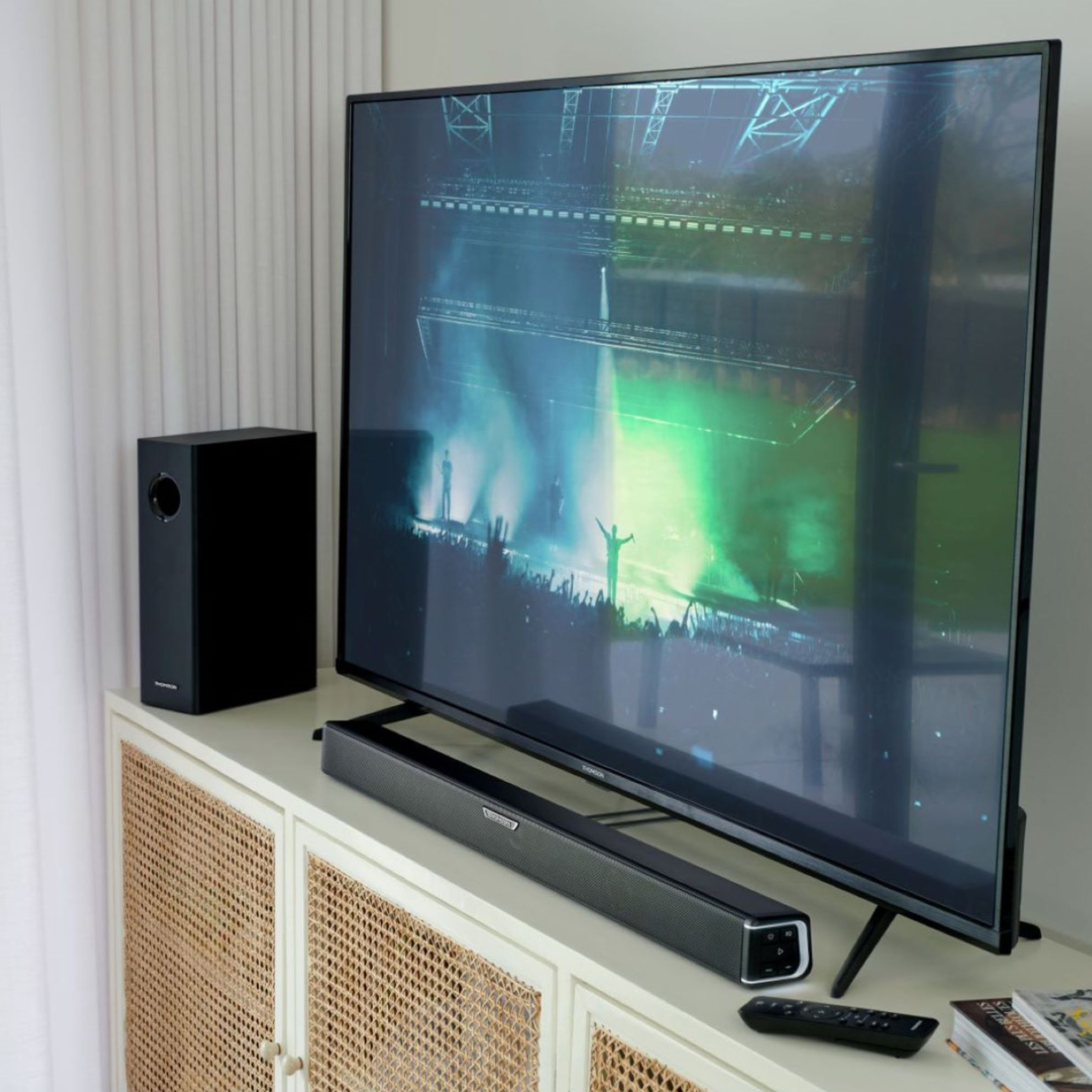 Telewizor i soundbar na szafce. Subwoofer obok. Scena na TV.