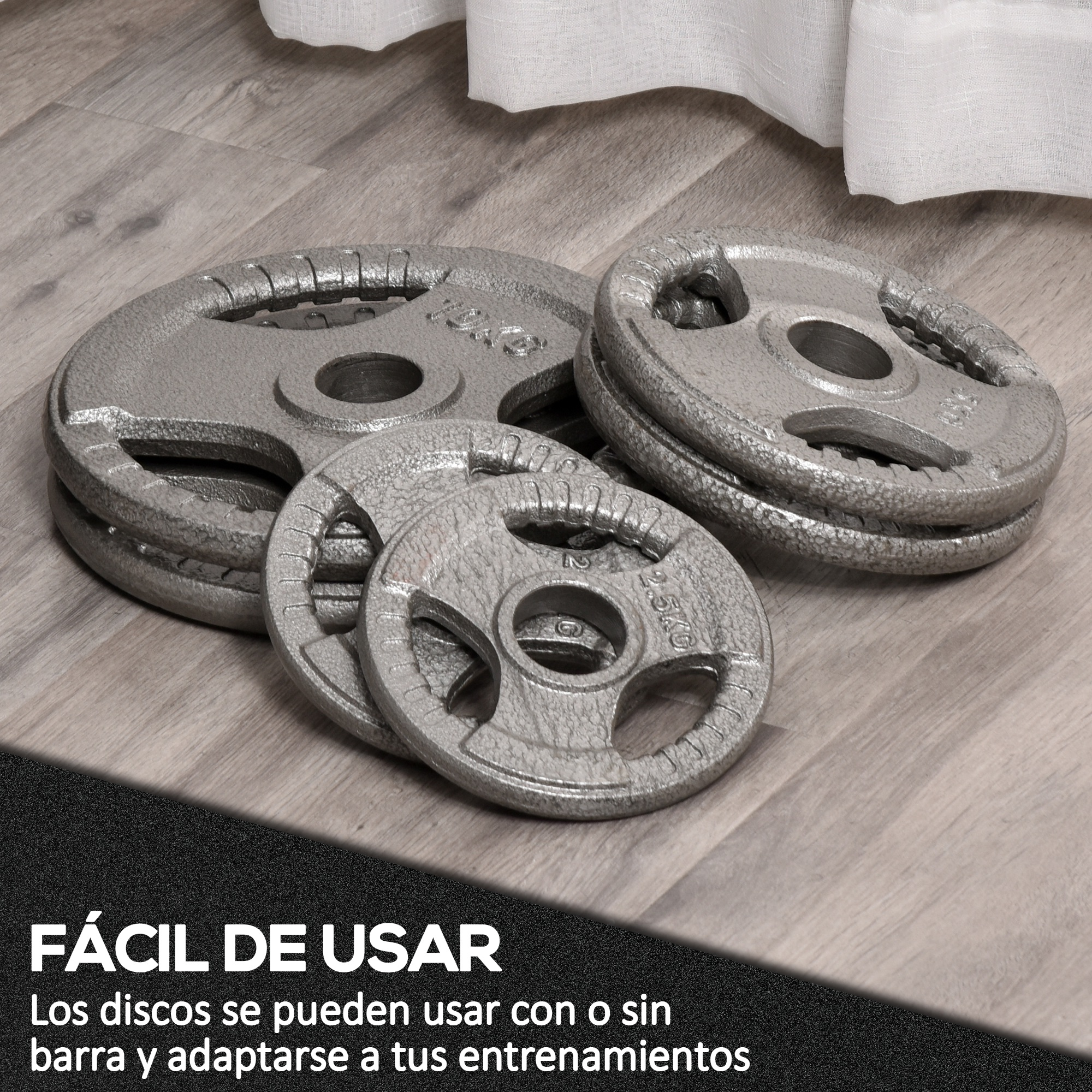 Platos de peso grises de varios tamaños sobre un piso de madera. Algunos están apilados. El fondo está desenfocado.
