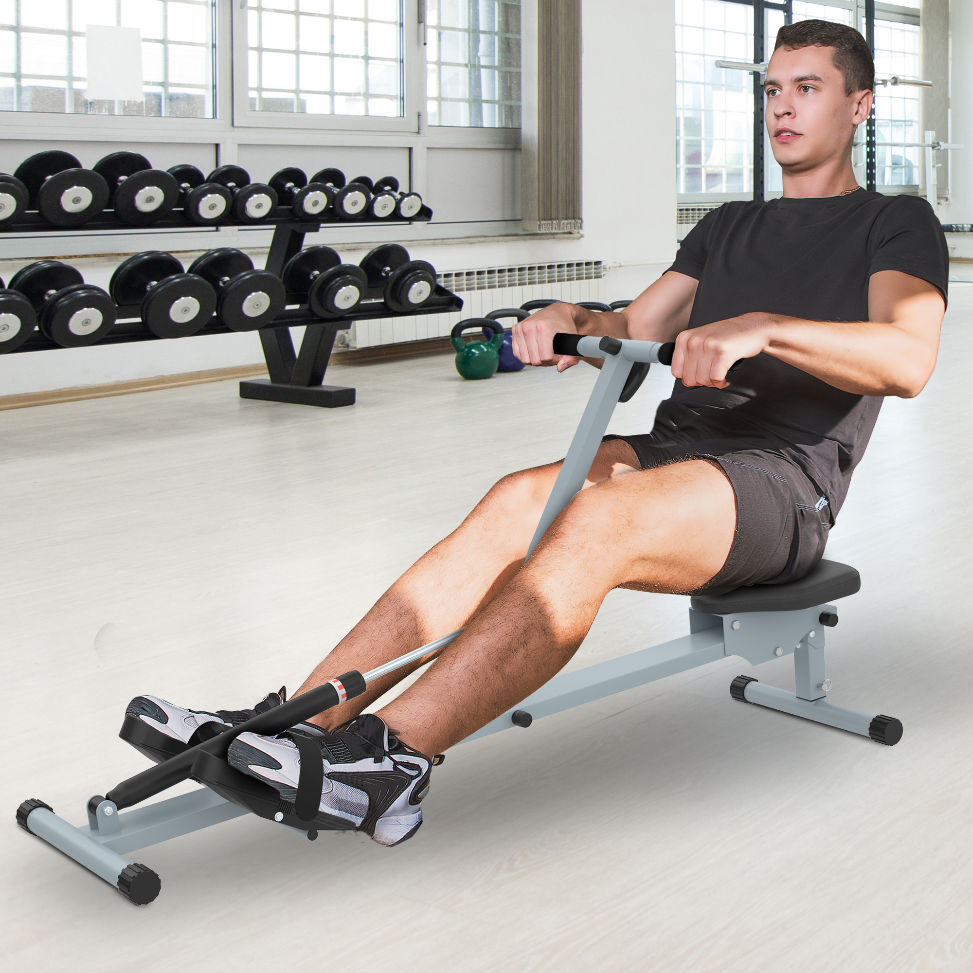 Hombre en una máquina de remo en un gimnasio. El fondo es un gimnasio.