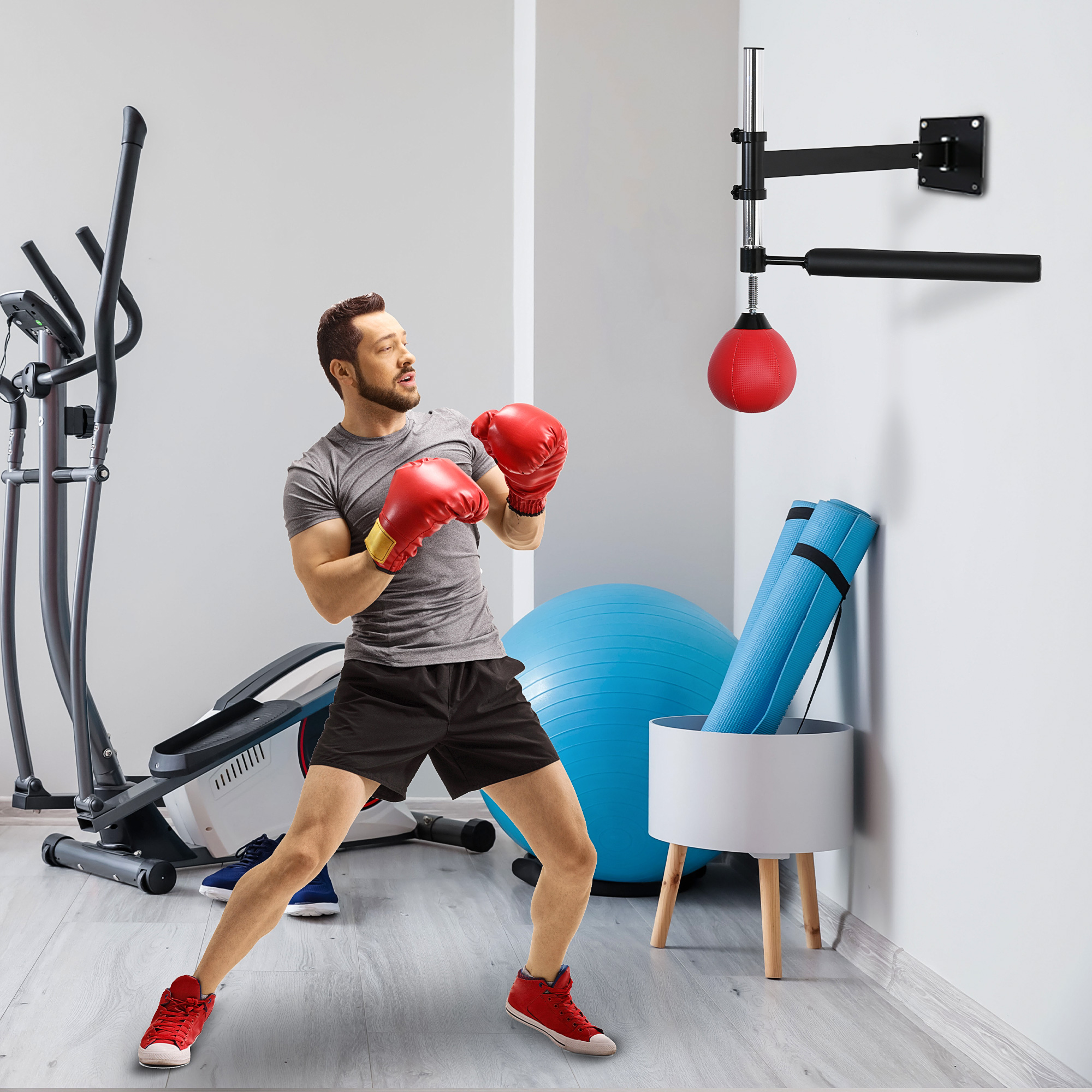 Hombre boxeando en un gimnasio en casa con guantes rojos. Hay un saco de boxeo y otros equipos de ejercicio.